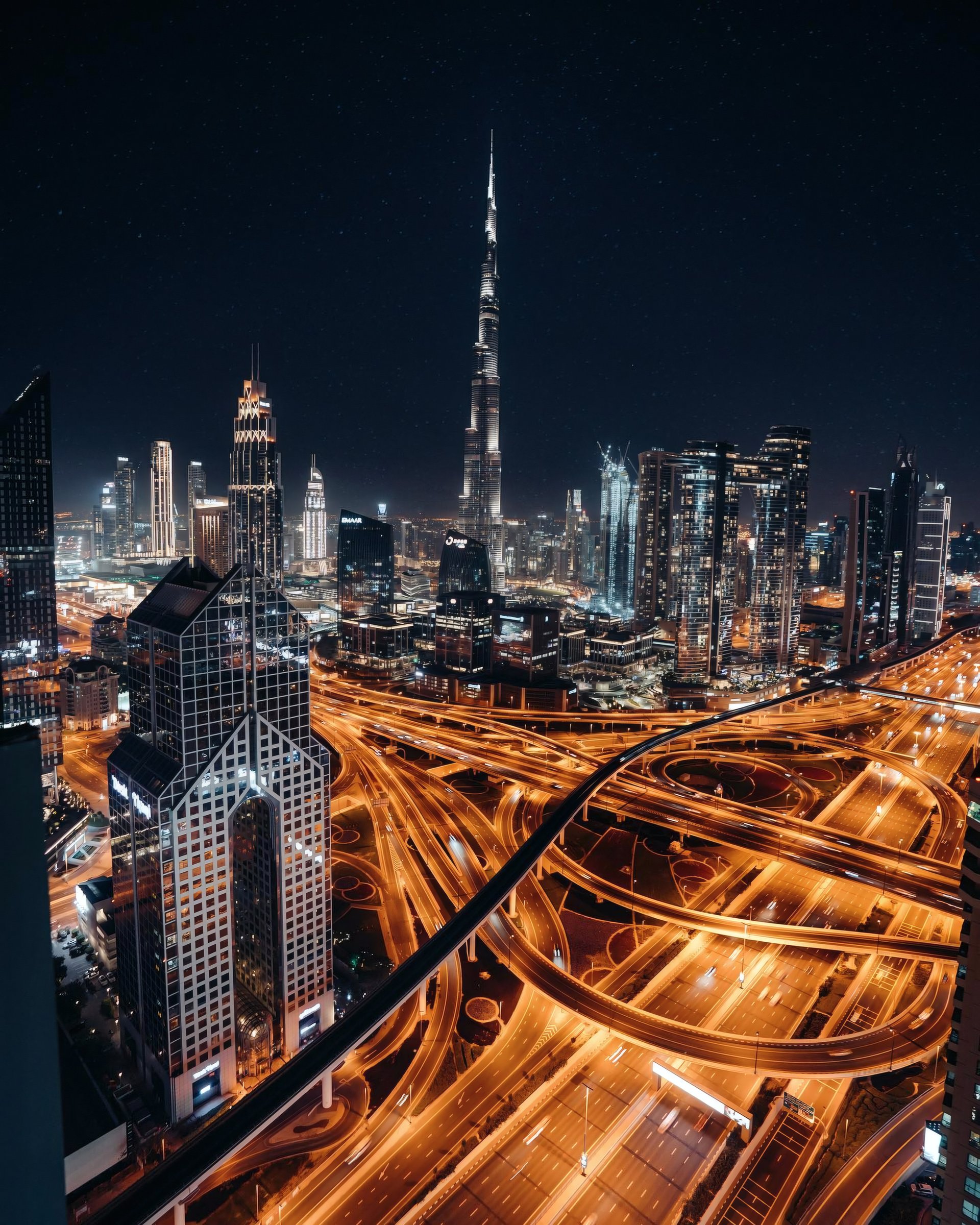 Dubai skyline and glowing highways at night.