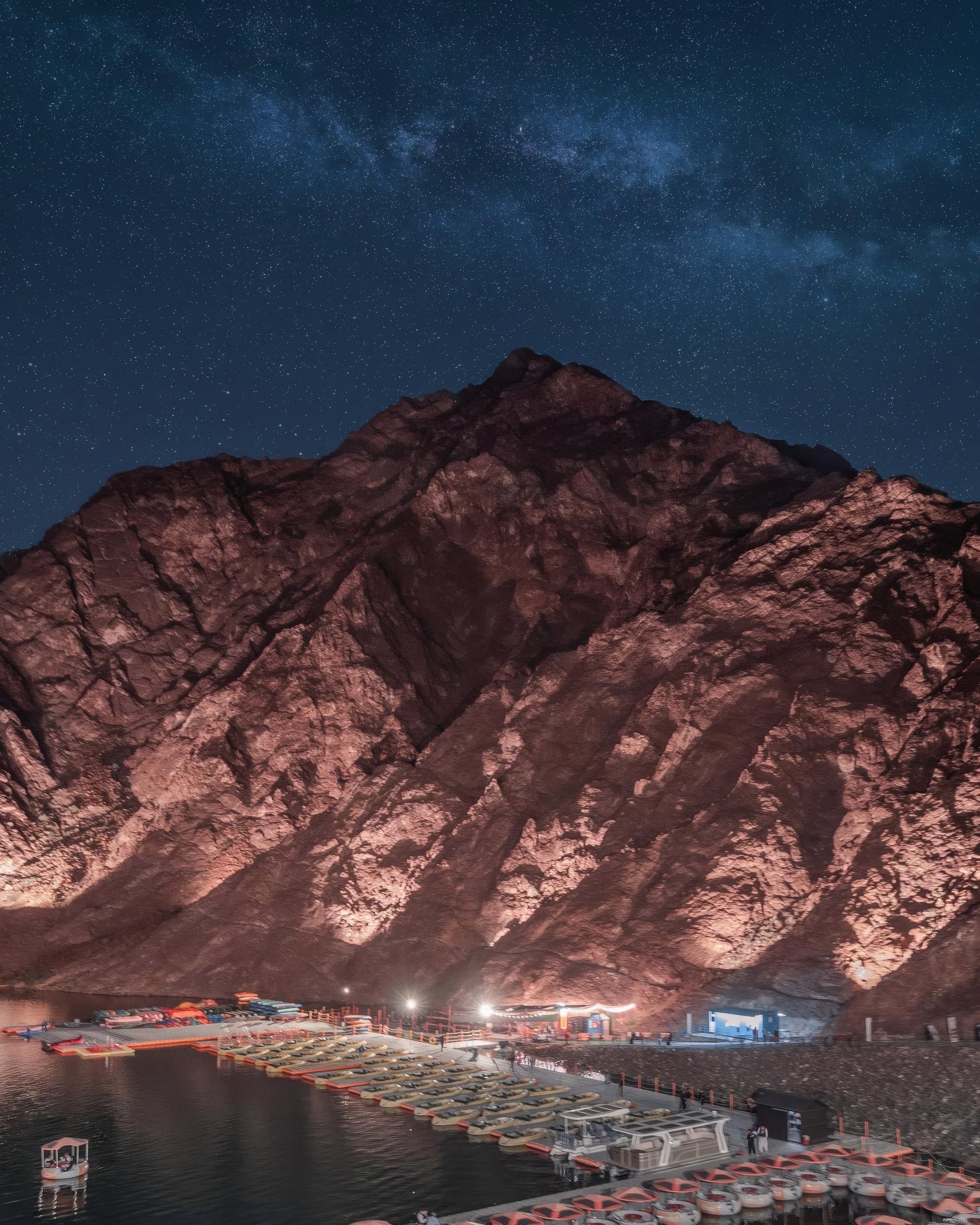 Rocky mountains beneath a dark blue night sky.